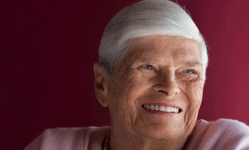 Ritratto di un'anziana signora con i capelli bianchi che sorride.
