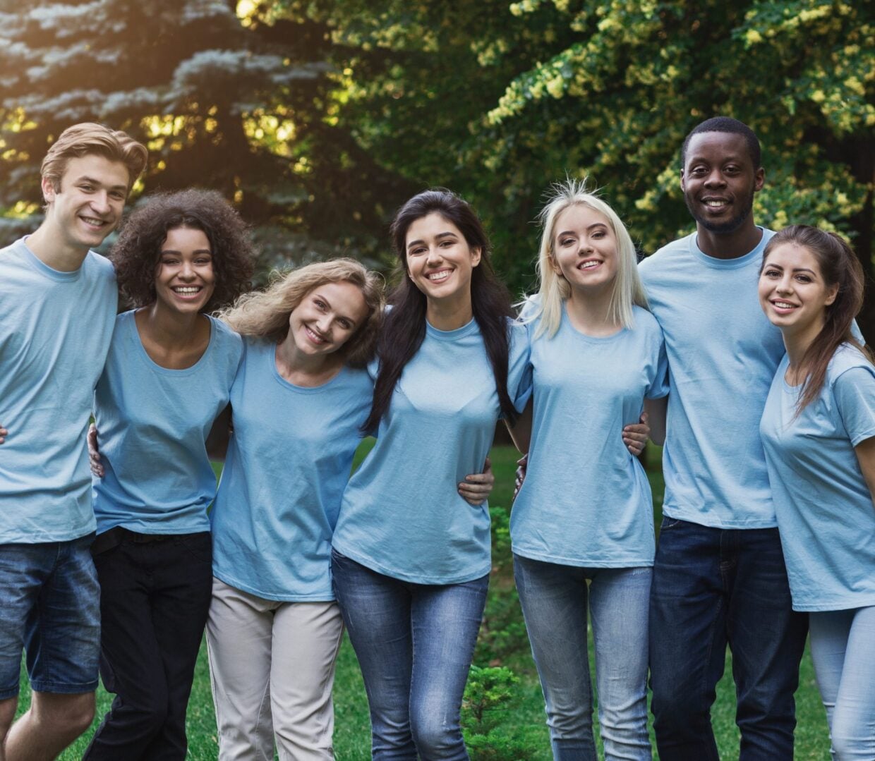 Group Of Young Volunteers Embracing At Park